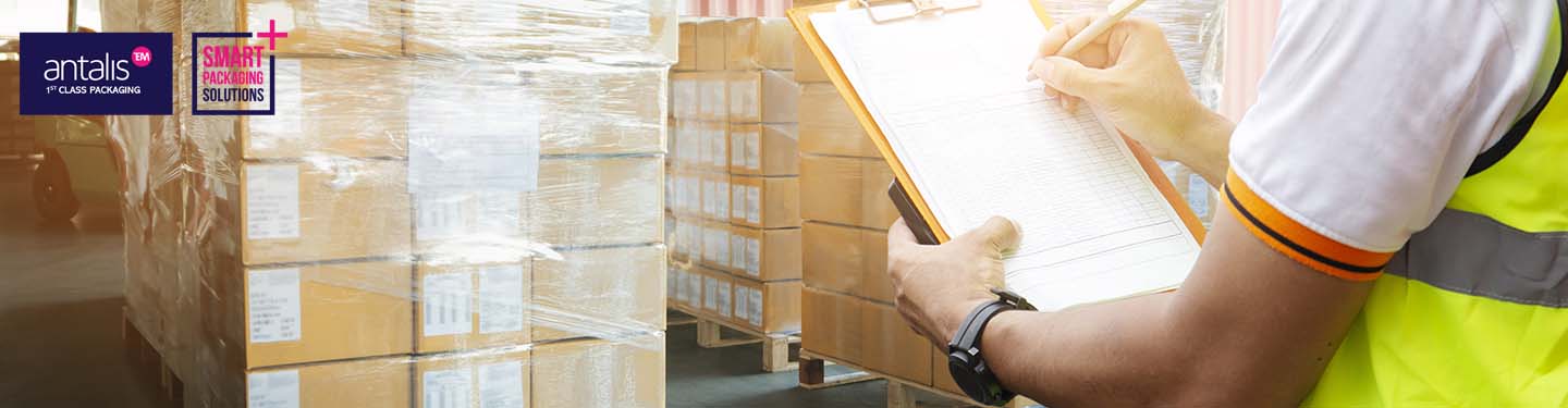packaging-audit_v2_1440x370.jpg (warehouse worker hand holding clipboard inspecting checklist. supply chain. cargo shipment goods pallets for loading with cargo container at dock warehouse. freight truck transport logistics.) 1st Class Services Banner