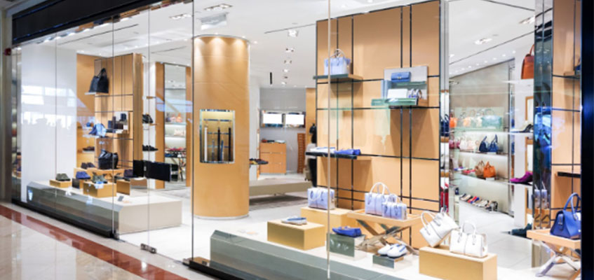 A window display of handbags, purses and shoes in a clothing retail store